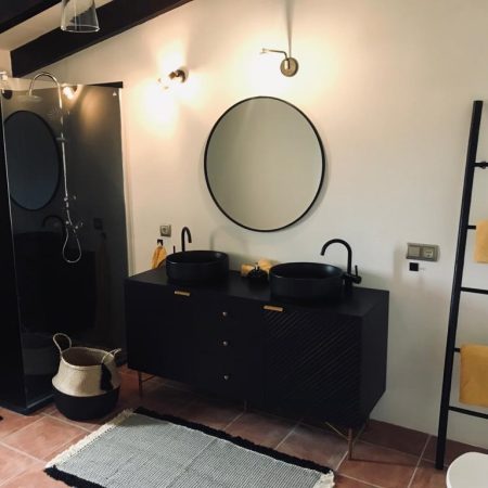 Modernes Badezimmer mit schwarzen Designelementen. Ausgestattet mit Regendusche, Waschbecken, Toilette und Fenstern.